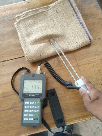 Moisture meter checking a jute bag, photo 1 of 4