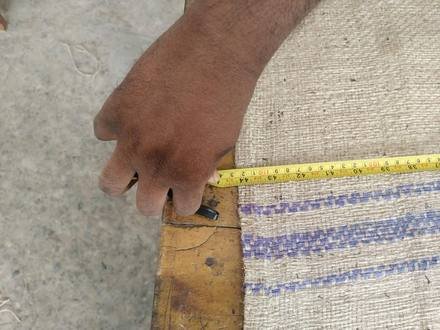 Measuring a jute bag with a tape, photo 4 of 21
