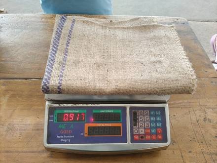Jute bag being weighed on a digital scale, photo 1 of 9